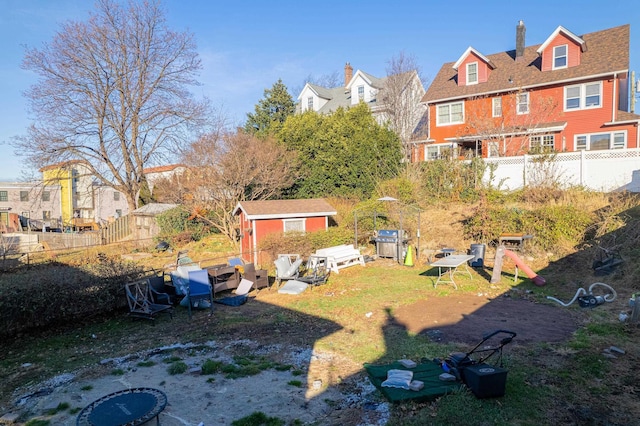 view of yard with an outbuilding, a fenced backyard, and a shed