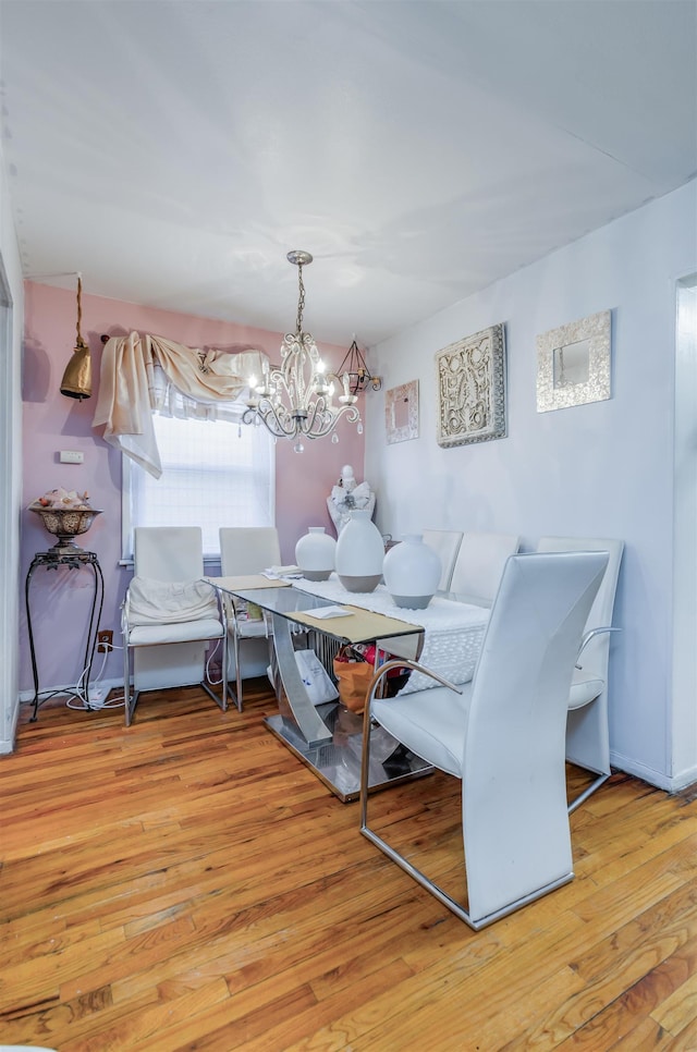 dining room with light wood-type flooring and a notable chandelier