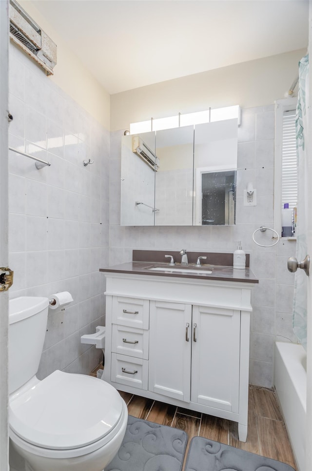 bathroom with vanity, tile walls, and toilet