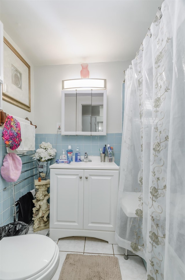 bathroom featuring tile patterned floors, vanity, tile walls, and toilet