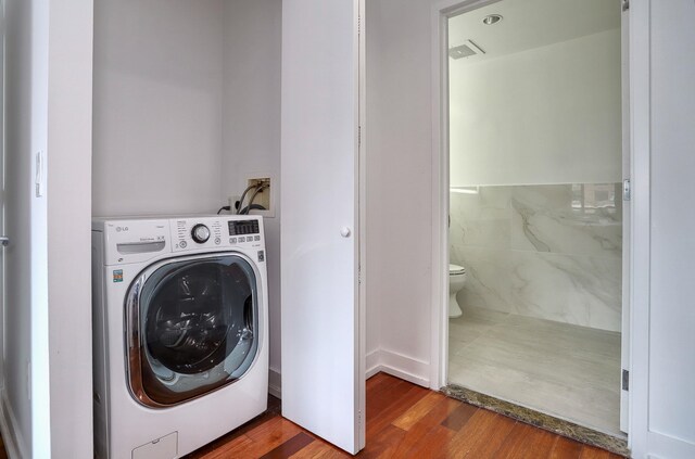 389 Washington St Unit 30C, Jersey City, NJ 07302 - laundry area with washer / dryer and wood finished floors