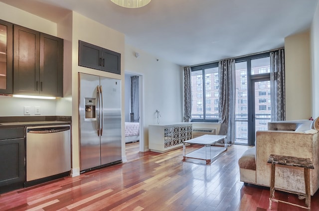 389 Washington St Unit 30C, Jersey City, NJ 07302 - kitchen with stainless steel appliances, wood finished floors, dark countertops, and dark brown cabinetry