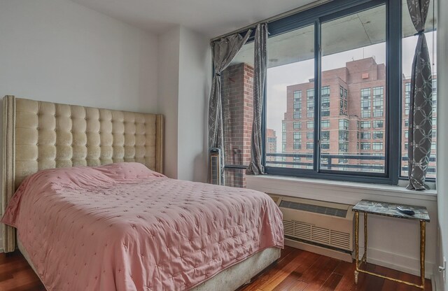 389 Washington St Unit 30C, Jersey City, NJ 07302 - bedroom featuring multiple windows, wood finished floors, and a city view