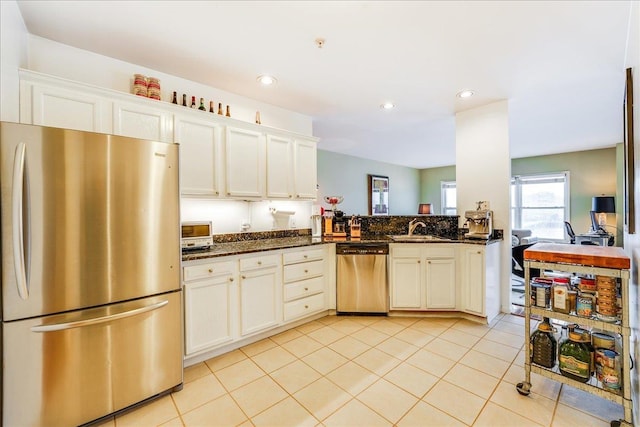 252 The Promenade Unit 252, Edgewater, NJ 07020 - kitchen with stainless steel appliances, light tile patterned floors, dark stone counters, and recessed lighting