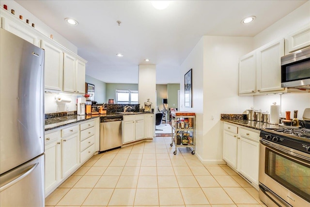 252 The Promenade Unit 252, Edgewater, NJ 07020 - kitchen with appliances with stainless steel finishes, light tile patterned floors, recessed lighting, dark stone counters, and white cabinetry