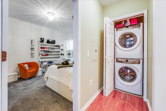 252 The Promenade Unit 252, Edgewater, NJ 07020 - washroom with stacked washer / dryer, electric panel, and wood finished floors