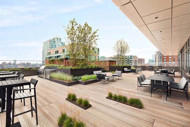 deck featuring exterior kitchen, a view of city, area for grilling, and outdoor dining space