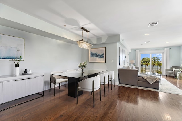 dining room with dark wood-style flooring, visible vents, and baseboards