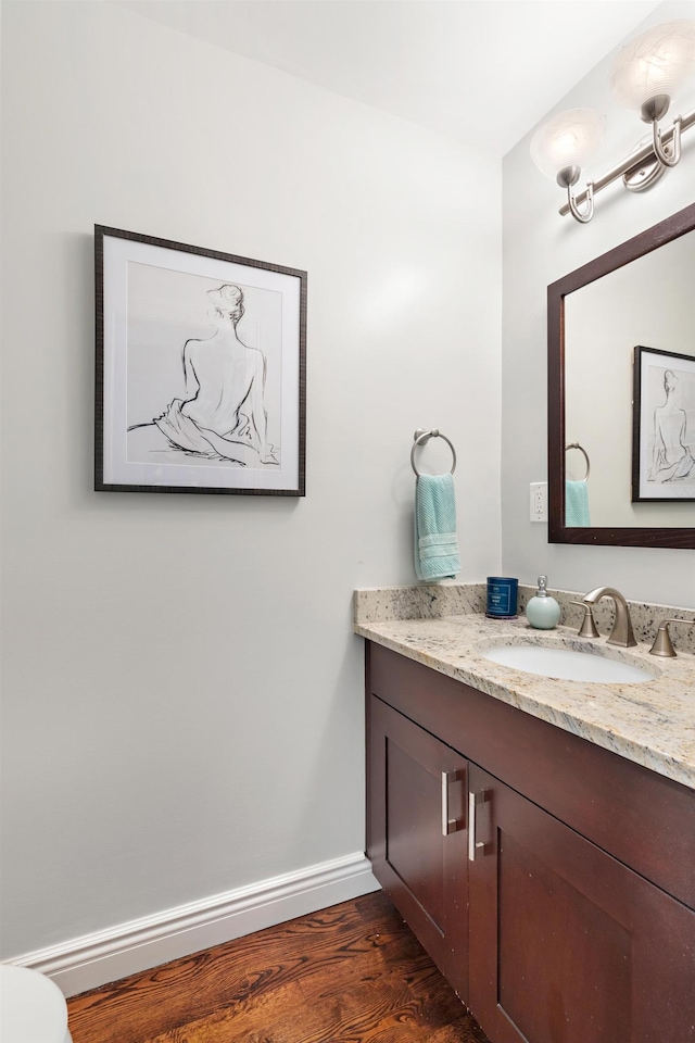 bathroom with baseboards, wood finished floors, and vanity