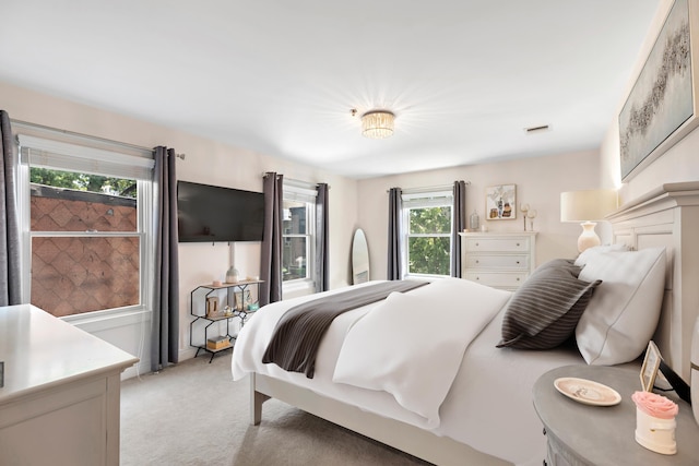 bedroom featuring visible vents and light carpet