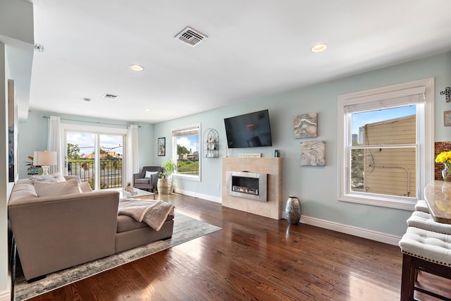 living room with a fireplace, recessed lighting, visible vents, dark wood-type flooring, and baseboards