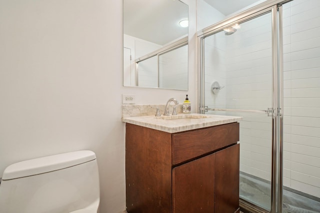 bathroom with vanity, a shower stall, and toilet