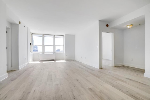 empty room with baseboards and light wood-style floors