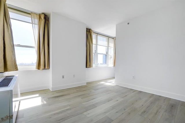 empty room featuring baseboards and light wood-style floors