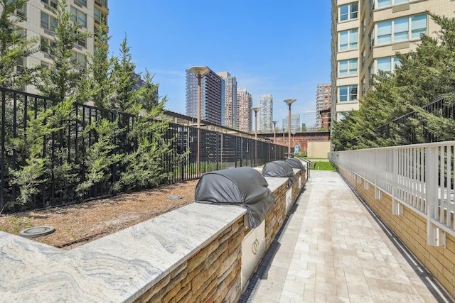 view of community featuring a city view, exterior kitchen, and fence