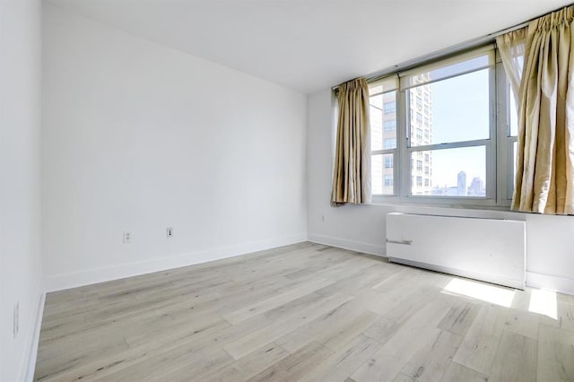 empty room with light wood-style flooring and baseboards