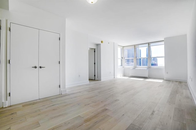 interior space featuring baseboards and light wood finished floors