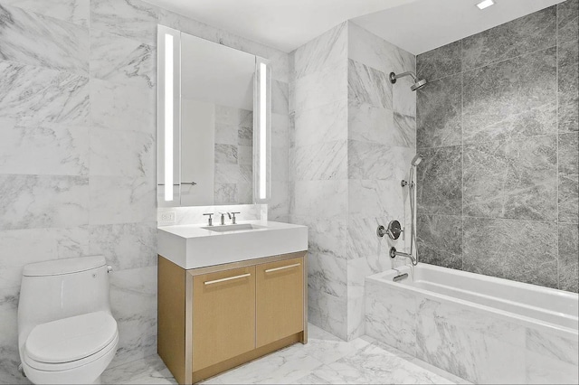 full bathroom featuring vanity, toilet, tile walls, and tiled shower / bath