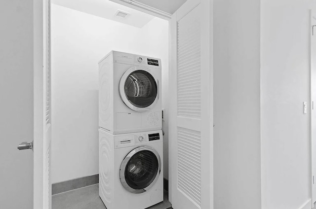 washroom featuring stacked washing maching and dryer