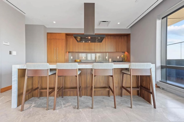 kitchen featuring a large island, a kitchen breakfast bar, and island range hood