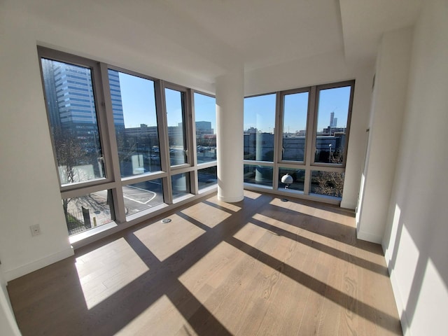 unfurnished sunroom featuring plenty of natural light and a view of city