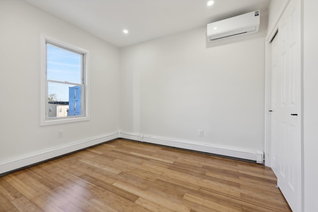 unfurnished room featuring light wood-style floors, recessed lighting, and a wall mounted AC