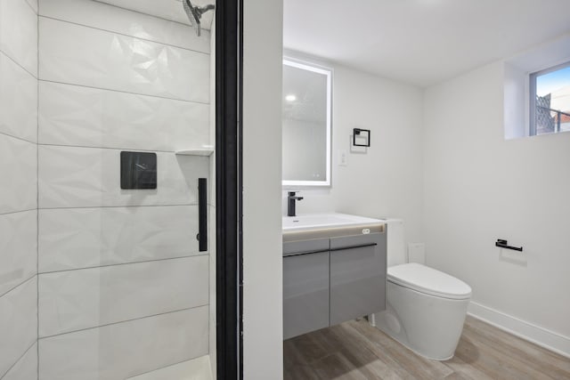 bathroom featuring baseboards, vanity, toilet, and wood finished floors