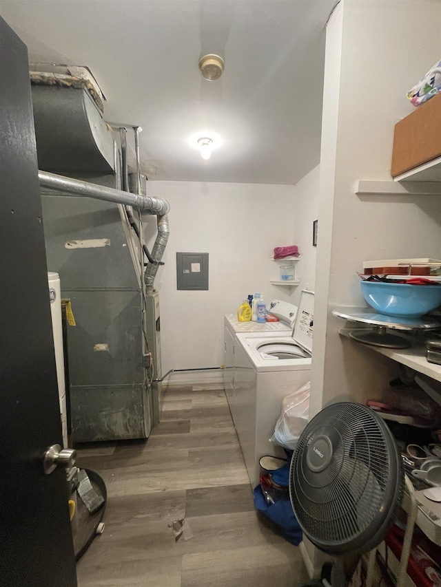 washroom with electric panel, hardwood / wood-style floors, and washing machine and dryer