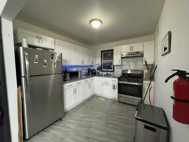 kitchen with stainless steel appliances, white cabinetry, sink, and decorative backsplash