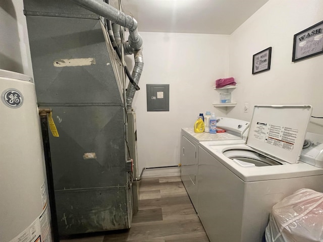 washroom featuring heating unit, gas water heater, dark hardwood / wood-style floors, electric panel, and independent washer and dryer