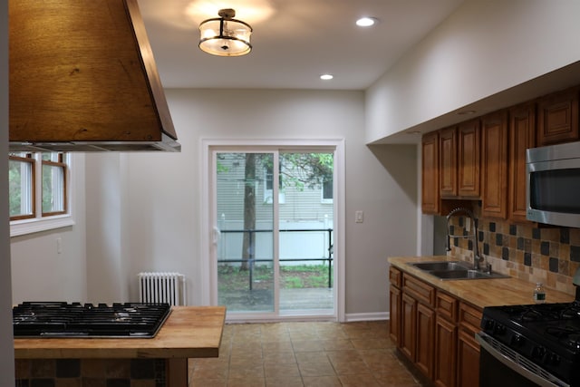 94 Lembeck Ave, Jersey City, NJ 07305 - kitchen featuring appliances with stainless steel finishes, radiator, backsplash, extractor fan, and recessed lighting