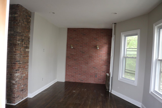 94 Lembeck Ave, Jersey City, NJ 07305 - unfurnished room featuring hardwood / wood-style flooring, brick wall, healthy amount of natural light, and radiator heating unit