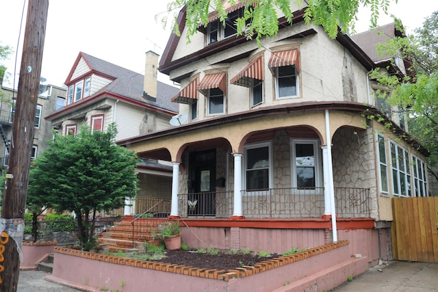 94 Lembeck Ave, Jersey City, NJ 07305 - victorian house with covered porch, stone siding, and stucco siding