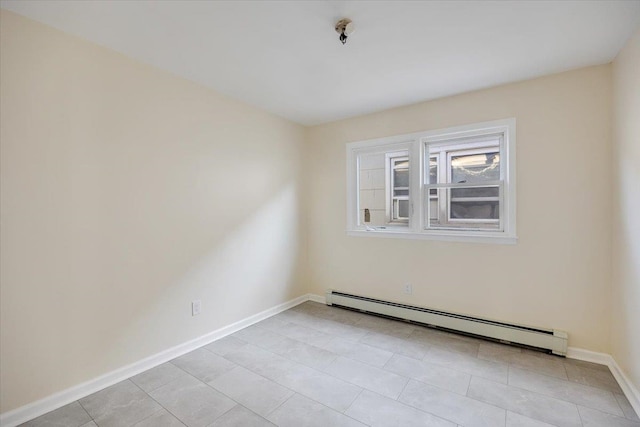 tiled spare room featuring baseboard heating