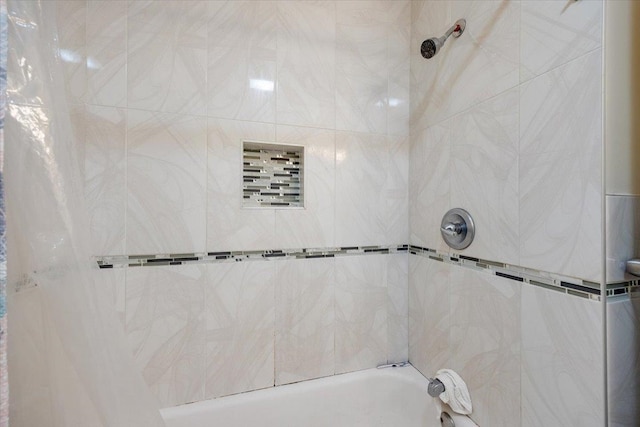 bathroom featuring tiled shower / bath