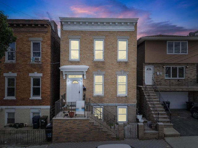 multi unit property featuring brick siding and a garage