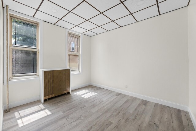 337 70th St, Guttenberg, NJ 07093 - empty room featuring light wood-style floors, baseboards, and a drop ceiling