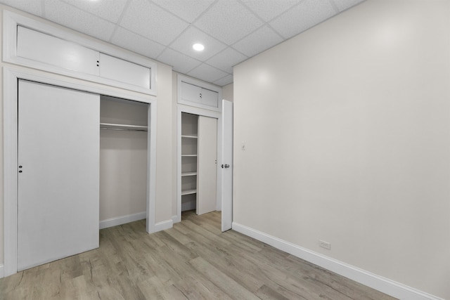 337 70th St, Guttenberg, NJ 07093 - unfurnished bedroom with light wood-type flooring, baseboards, recessed lighting, and a paneled ceiling