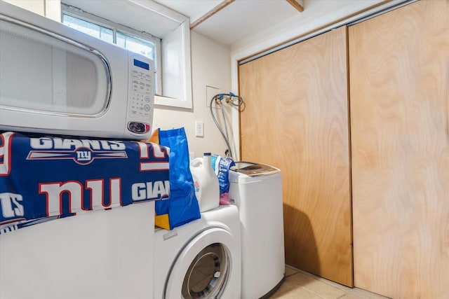 clothes washing area with laundry area and light tile patterned floors