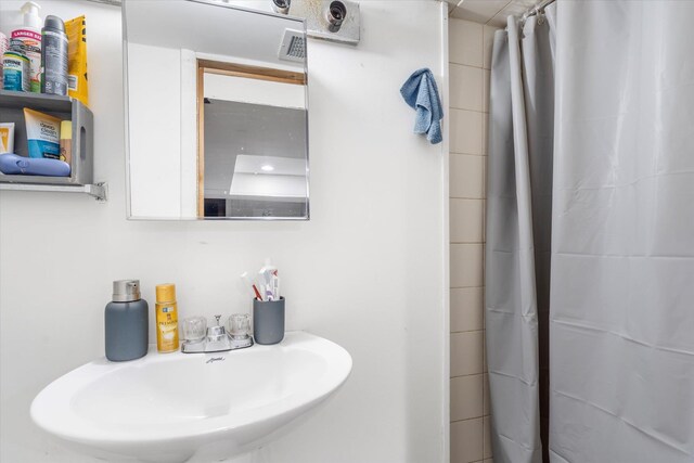 full bath featuring a sink, visible vents, and a shower with shower curtain