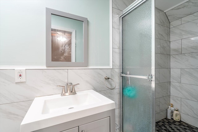 bathroom featuring tasteful backsplash, tile walls, a stall shower, and vanity