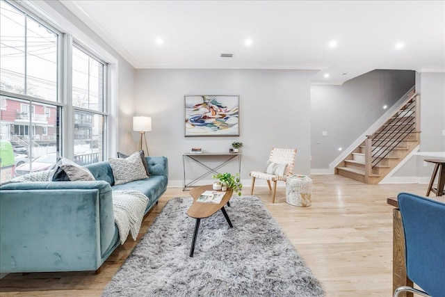 living room with light wood-type flooring and crown molding