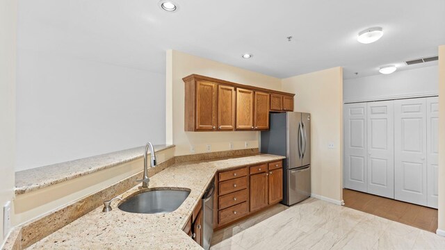 344 The Promenade Unit 344, Edgewater, NJ 07020 - kitchen with visible vents, brown cabinets, light stone counters, a sink, and stainless steel appliances