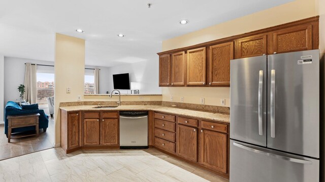 344 The Promenade Unit 344, Edgewater, NJ 07020 - kitchen featuring brown cabinetry, appliances with stainless steel finishes, light stone countertops, a sink, and recessed lighting