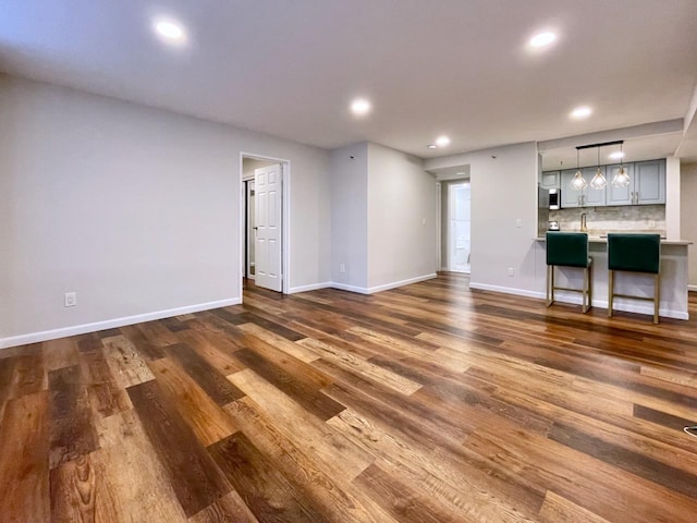 43 Van Wagenen Ave Unit Ga, Jersey City, NJ 07306 - unfurnished living room with dark wood-type flooring, recessed lighting, and bar with sink