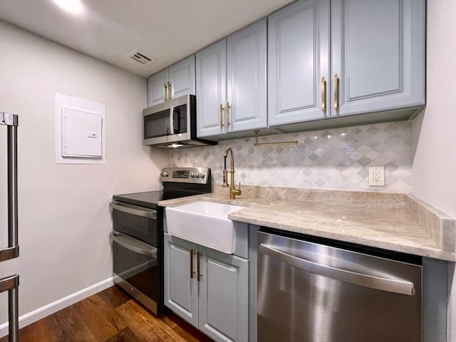43 Van Wagenen Ave Unit Ga, Jersey City, NJ 07306 - kitchen featuring stainless steel appliances, gray cabinetry, dark wood-style floors, backsplash, and light stone countertops