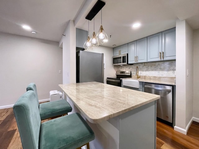 43 Van Wagenen Ave Unit Ga, Jersey City, NJ 07306 - kitchen featuring stainless steel appliances, backsplash, dark wood finished floors, a breakfast bar, and hanging light fixtures