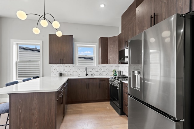 28 Cambridge Ave Unit 2, Jersey City, NJ 07307 - kitchen with light countertops, a sink, backsplash, appliances with stainless steel finishes, and a peninsula