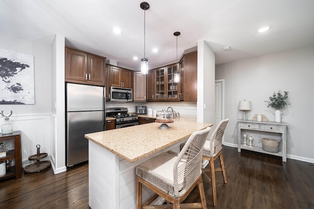 456 9th St Unit 458, Hoboken, NJ 07030 - kitchen featuring appliances with stainless steel finishes, a peninsula, glass insert cabinets, a breakfast bar area, and dark wood-type flooring