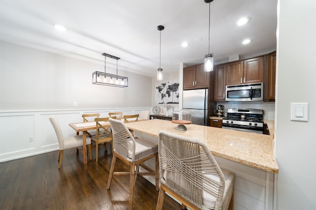456 9th St Unit 458, Hoboken, NJ 07030 - kitchen with stainless steel appliances, a kitchen breakfast bar, a peninsula, dark wood-style flooring, and light stone counters
